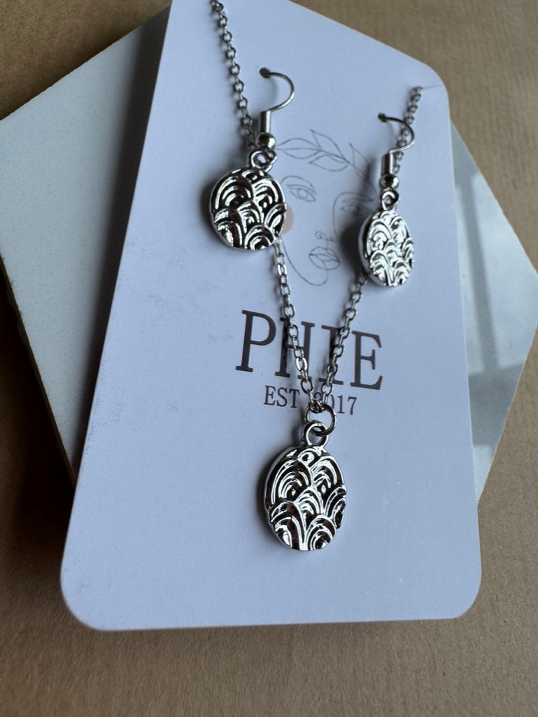 Silver necklace and earrings on a Phie branded card