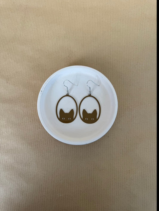 brown Cat-shaped earrings on a white circular card with a beige background