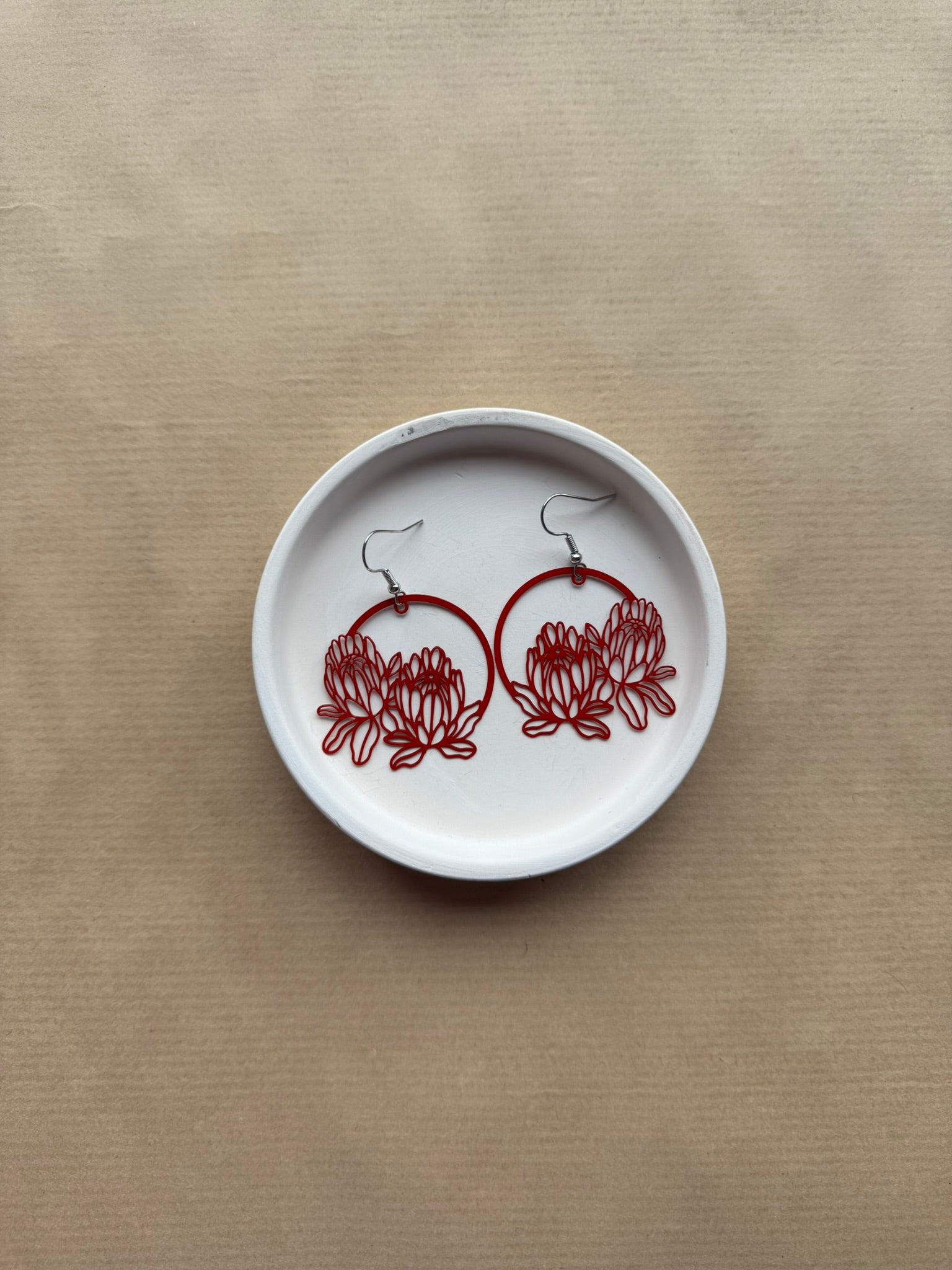 White dish with red floral designs on a beige background